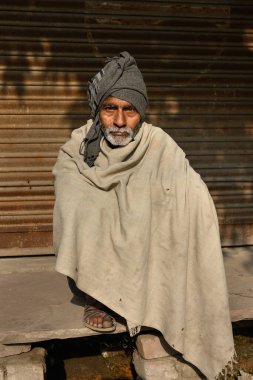 Agra, Uttar Pradesh, Hindistan - 21 Şubat 2025: Geleneksel Basit Giyimli Hintli Müslüman Adam Kaldırımda Oturuyor, Türban Giyiyor.