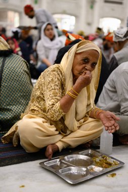 Delhi, Hindistan - 21 Şubat 2025: Gurudwara Bangla Sahib Sikh Tapınağındaki Langar Halk Yemeğinde Kadın Mercimek Yiyor