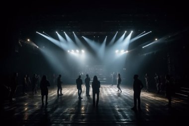 Bir müzik festivalinde ışık gösterisi. Sahnedeki insanlar. Siluetler ve ışık demetleri