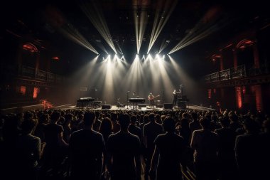 Bir müzik festivalinde ışık gösterisi. Sahnedeki insanlar. Siluetler ve ışık demetleri