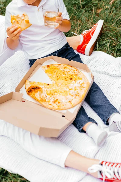 Pizza picnic. Mom and son eat pizza. Delicious pizza Four Cheeses with cheddar, Parmesan, mozzarella and tomato sauce