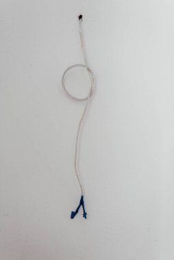 Duvardan sarkan bir elektrik kablosu. Yalıtımlı elektrik kablosu. 