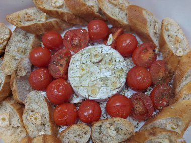 Domates, baget, otlar ve sarımsaklı peynirli camembert peyniri. Şarap için mükemmel bir aperatif. Yukarıdan görüntüle. 