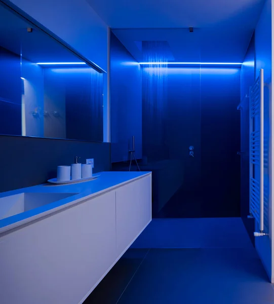 青いLedライトで照らされた開放的な水でシャワーのフロントビュー 左側にはシンクと大きな鏡の上です 誰も中に — ストック写真