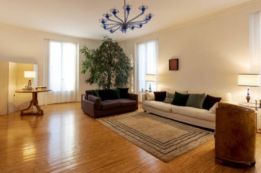 Büyük koltukları ve koltukları olan zarif bir oturma odası. Modern mobilyaları olan klasik bir daire. İçeride kimse yok.