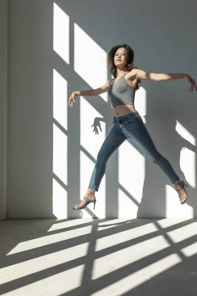 Azjatycka Tancerka Wykonuje Akrobatyczny Skok Oświetlony Słońcem Który Wchodzi Przez — Zdjęcie stockowe