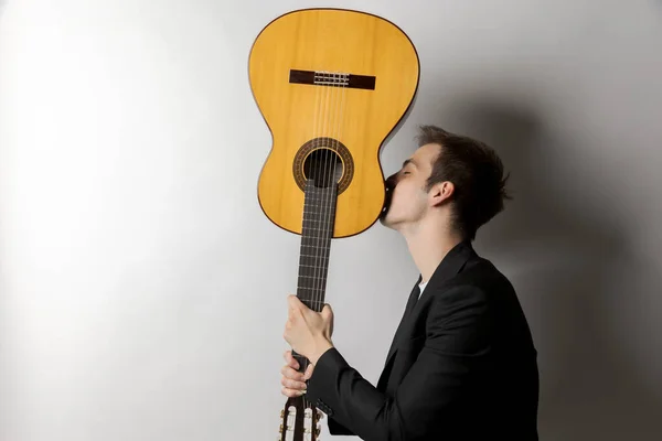 Joven Sostiene Guitarra Boca Abajo Besa Aislado Sobre Fondo Blanco — Foto de Stock
