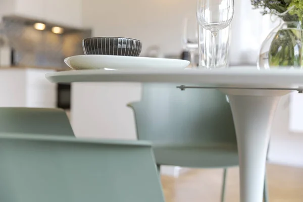 トルコ石の椅子と皿付きの白いテーブルの詳細 キッチンは背景にあります 誰も中に — ストック写真