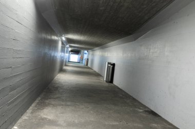 İsviçre 'deki Melide tren istasyonunun altından geçen uzun beton yaya koridoru. İçeride kimse yok.