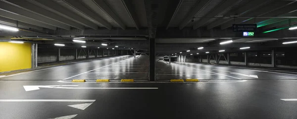シーンを照らすランプ付きのモダンな地下ガレージ 駐車場は床に描かれています 誰も中にいない — ストック写真