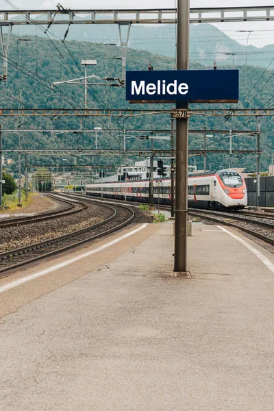 Stacja Melide Niebieski Znak Nazwą Stacji Nadjeżdża Pociąg Dużych Prędkości — Zdjęcie stockowe