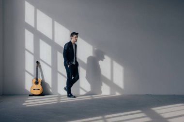 Ayakta duran bir çocuk elleri cebinde gitarından uzaklaşıyor. O siyah bir takım elbise giyiyor. Yenilenmiş eski bir fabrikanın içinde..