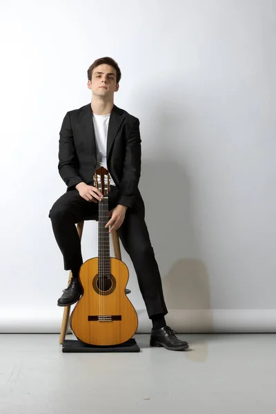 Jovem Sentado Banco Terno Preto Segura Sua Guitarra Clássica Madeira — Fotografia de Stock