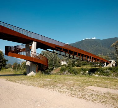 Paslanmış modern yaya ve altında akan Ticino nehri olan bisiklet köprüsü. Güneşli bir yaz gününde İsviçre Alpleri 'nin dağ manzarası. İçeride kimse yok.