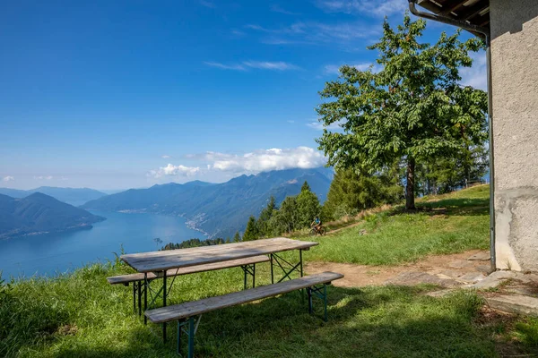 スイスのマッジョーレ湖のパノラマビュー 2つのベンチと木製のテーブルは高高度の夕食の夢を作ります — ストック写真