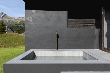 İsviçre Alpleri ve dağlarının ortasında bir serinleme havuzu. Yetişkinler için bir çeşme. Ayrıntı ve ön görünüm