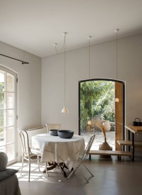 Mutfak önü, masa ve sandalyeler solda, mobilyalar sağda. İçi modern ve minimalist. İçeride kimse yok..