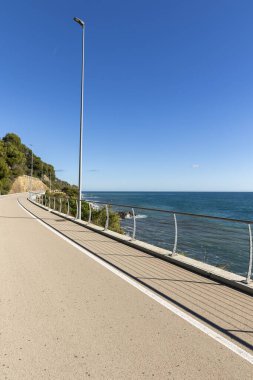 Etrafında kimsenin olmadığı denize bakan uzun bir bisiklet yolu. Güzel güneşli bir gün