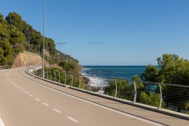 Etrafında kimsenin olmadığı denize bakan uzun bir bisiklet yolu. Güzel güneşli bir gün