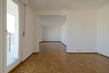 Doğal ışık için pencereleri olan boş bir odanın ön görüntüsü. Parke zemin. İçeride kimse yok.