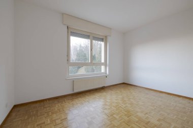 Boş bir yatak odası, parke ve bir sürü ışığın girdiği bir pencere. İçeride kimse yok.