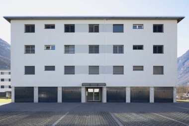 Garajları ve otoparkları olan bir apartmanın girişi. İçeride kimse yok.