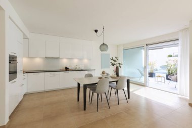 Büyük mutfak ve yemek odası olan bir daire. Bir terasa bak.