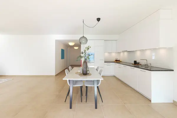 Große Moderne Weiße Küche Mit Einem Marmortisch Und Vier Stühlen lizenzfreie Stockbilder