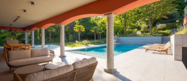 Güpegündüz güzel bir yüzme havuzu manzarası. Rahatlamak için kemerlerin altında bir dinlenme odası. Lüks bir ortam.