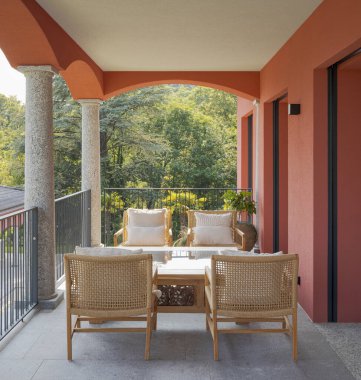 Relaxation area with four armchairs and a small table on a balco clipart