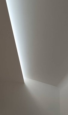 Bir ışık şeridiyle aydınlatılmış beyaz bir tavanın ayrıntıları. Tüm duvarlar beyazdır..