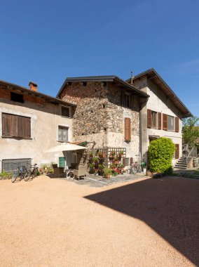 Bağlı tatil evleri, İtalyan tarzı, büyük bir bahçesi ve park edilmiş bisikletleri var. Güçlü gölgelerle güneşli bir yaz günü.