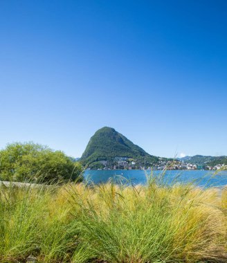 Lugano Gölü ve Svittera 'daki San Salvatore Dağı manzarası. Güneşli yaz, bahar ve mavi gökyüzü ile harika bir hava.