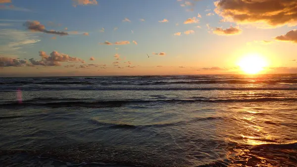 Okyanus manzarası gün doğumunda, güneş en sağda.