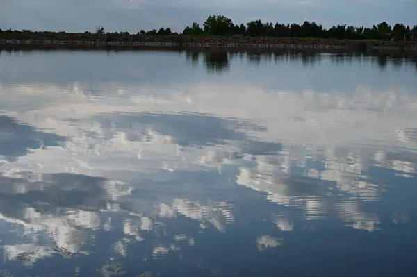 Bulutlar akşam gölüne yansıyor