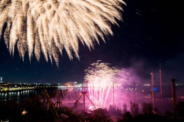 27 Haziran 2024 'te Uluslararası Havai fişek Festivali' nde lunapark yakınlarında. Montreal. Suyun üstünde bayram havai fişekleri