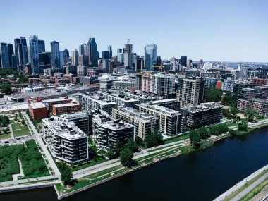 Gökdelenlerin yoğun bir silueti ve yeşil yerleşim alanının yer aldığı modern bir şehrin havadan çekilmiş fotoğrafı. Griffintown, Montreal, Quebec, Kanada.