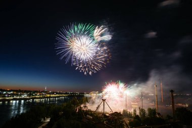 Suyun üstünde kara gökyüzü arka planında yansıması olan bayram havai fişekleri.