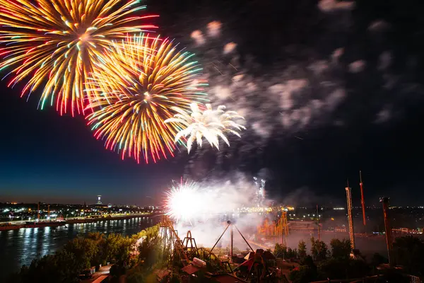 stock image Holiday fireworks above water with reflection on the black sky background.