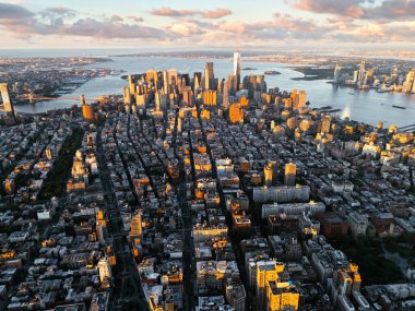 Arka plandaki gündoğumu bulutları sırasında Manhattan 'ın şehir merkezinin yukarıdan çekilmiş bir fotoğrafı. New York, ABD.