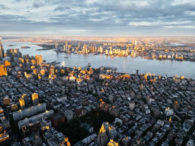 Manhattan şehir merkezindeki Hudson Nehri 'nin ve New Jersey' nin güneş doğarken çekilmiş fotoğrafı. Arka planda bulutlar var. New York, ABD.