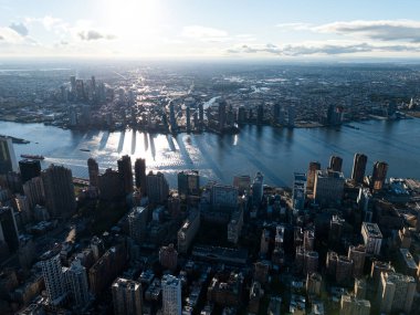 Arka plandaki gündoğumu bulutları sırasında Manhattan 'ın şehir merkezi, doğu nehri ve Brooklyn' in yukarıdan çekilmiş bir fotoğrafı. New York, ABD.