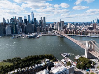 Görkemli Brooklyn Köprüsü New York siluetini şereflendiriyor. Yükselen çelik kemerler şehir manzarasını çerçeveler, sıcak güneş ışığıyla yıkanır. Seyahat ve mimari projeleri için ikonik simge.
