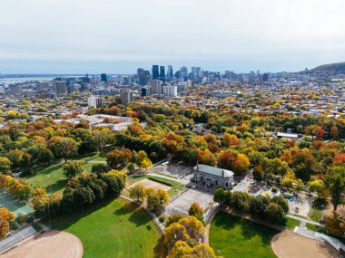 Halka açık bir park, sonbahar yaprağı rengi değişimi, şehir merkezindeki gökdelenler..