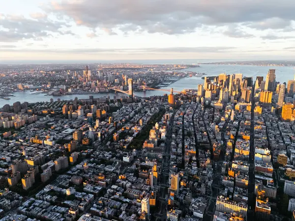 Arka plandaki gündoğumu bulutları sırasında Manhattan 'ın şehir merkezi, doğu nehri ve Brooklyn' in yukarıdan çekilmiş bir fotoğrafı. New York, ABD.