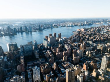 Arka plandaki gündoğumu bulutları sırasında Manhattan 'ın şehir merkezi, doğu nehri ve Brooklyn' in yukarıdan çekilmiş bir fotoğrafı. New York, ABD.