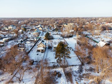 Kış boyunca Kazakistan 'ın Uralsk kentindeki donmuş nehrin yakınındaki karla kaplı evlerin hava manzarası. c.