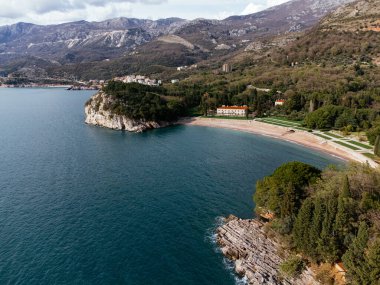 Karadağ 'ın Adriyatik Denizi kıyısındaki kıyı köyüne bağlanan ada otelinin havadan görünüşü. c.