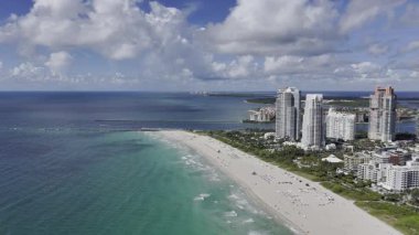 Güney Pointe Sahili 'nin, Fisher Adası' nın ve Miami şehir merkezinin mavi gökyüzünün altındaki gökyüzü manzarası. c.