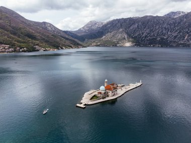 Karadağ 'ın Kotor Körfezi' ndeki Perast yakınlarındaki Saint George Adası 'nın sakin deniz ve dağlarla çevrili havadan görünüşü. g.